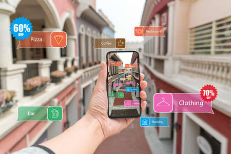 Augmented reality marketing street . Hand holding smart phone use AR application to check...