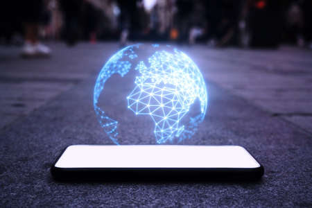 Smartphone lie on the ground, The earth is displayed above the mobile phone, technology conceptの写真素材