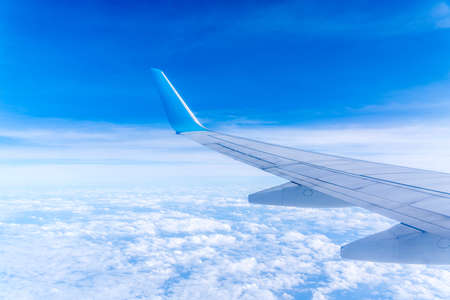 Wing of an airplane cruising above the cloudsの写真素材