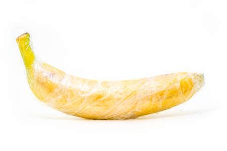 yellow banana is wrapped by plastic film, protection conceptの写真素材