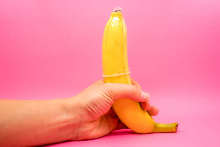 hand holding the banana, Transparent condom placed on banana. concpt of sexual protectionの写真素材