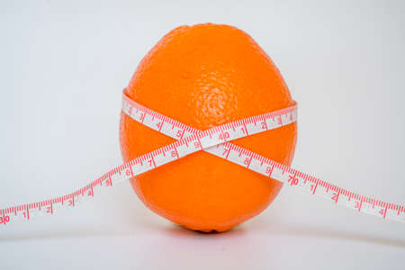 orange standing on the table with rulerの写真素材