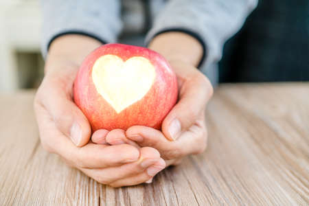 hand holding apple pie with heart shape, concept of loveの写真素材