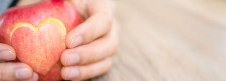 hand holding apple pie with heart shape, concept of loveの写真素材