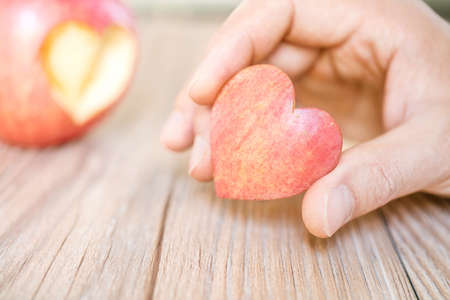 hand holding apple pie with heart shape, concept of loveの写真素材
