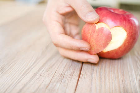 hand holding apple pie with heart shape, concept of loveの写真素材