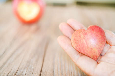 hand holding apple pie with heart shape, concept of loveの写真素材