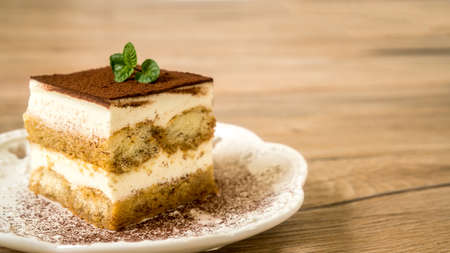 Fresh Tiramisu Cake on the table, white backgroundの写真素材