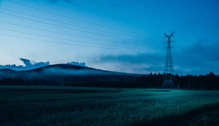 Silhouettes of rural scenery, crops, mountains and high-voltage power poles
