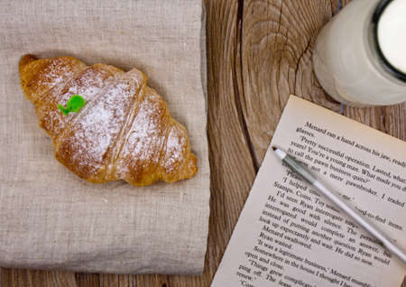 breakfast on the table, croissant, paper, pen, milkの写真素材