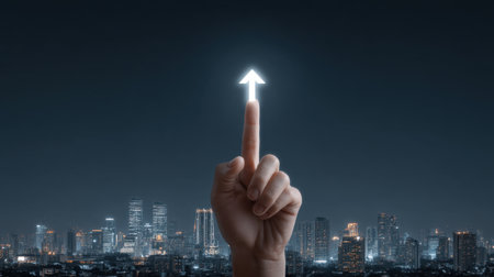 A hand with a finger pointing upward, showcasing a glowing arrow against a dark city skyline. This image represents ambition, growth, and future possibilities in an urban setting.の素材