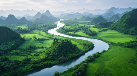A breathtaking view of a winding river surrounded by verdant hills and mountains, showcasing the tranquility and beauty of nature in a pristine landscape.の素材
