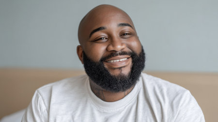 A cheerful man showcases his bright smile in a cozy indoor space, radiating warmth and happiness. His relaxed demeanor invites viewers to connect with joy and positivity.の素材