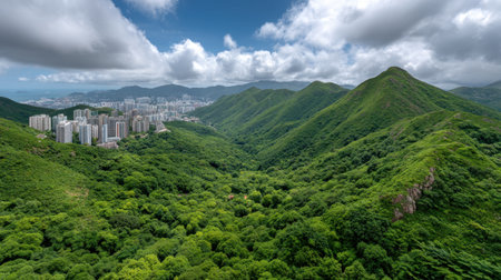 A breathtaking view of green mountains surrounding urban development under a dramatic sky, showcasing the harmony between nature and city life in Hong Kong.の素材