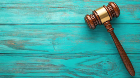 A striking turquoise background contrasts with a wooden gavel, symbolizing the intersection of justice and modern law.の素材