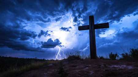 A weathered wooden cross on a hill, silhouetted against a stormy sky filled with thunder and lightningの素材