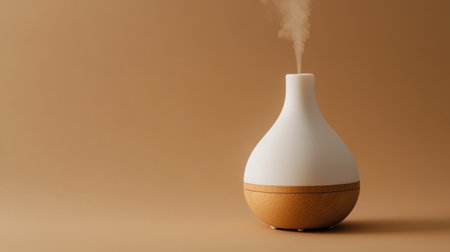 Modern white and wooden essential oil diffuser, displayed on a tan background, blending functionality with natural designの素材