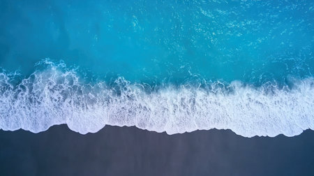 An aerial perspective showcasing gentle ocean waves rolling onto a tranquil beach. The vibrant blue water contrasts beautifully with the white foam, creating a peaceful coastal atmosphere.の素材