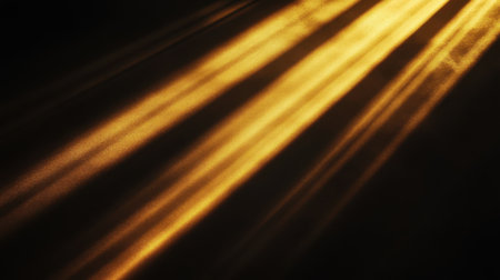 Radiant golden sun rays glowing against a pitch-black background, creating a dramatic contrast of light and shadowの素材