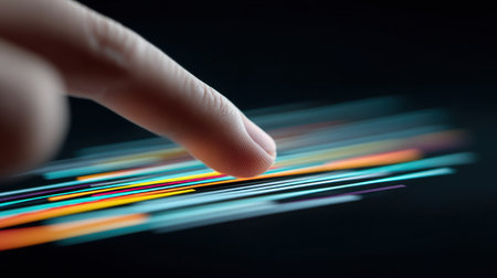 A close-up view captures a finger gliding over vibrant neon lines against a dark backdrop, showcasing a blend of motion and color that symbolizes innovation and creativity.の素材