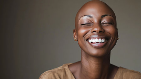 A cancer survivor, bald and smiling, captured in a warm, intimate portrait, symbolizing hope and resilience.の素材