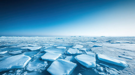 Cracked sea ice floes under a clear blue sky, showcasing the vast, frozen Arctic landscape and highlighting the impacts of climate change.の素材