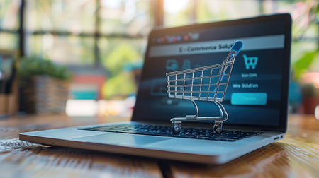 Laptop screen showing "E-Commerce Solution" and a shopping cart icon, representing seamless online shopping experiences and innovative digital solutions for consumers.の素材
