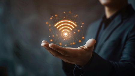Closeup of businessman with digital Wi-Fi symbol over his hand, wireless tech concept.の素材