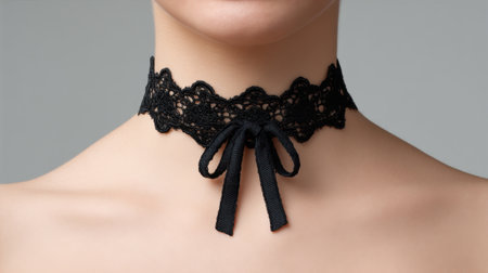 A captivating image of a stylish black lace choker adorned with a satin ribbon bow, elegantly resting on a bare neck. Ideal for fashion and accessory inspirations.の素材