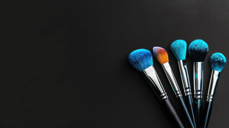 Elevate your beauty game: Vibrant makeup brushes against a black background, ideal for beauty industry banners, with space for your message.の素材