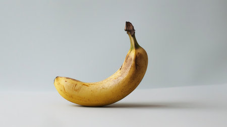 Contemporary photograph of a lone banana against a white backdrop, perfect for modern design projectsの素材