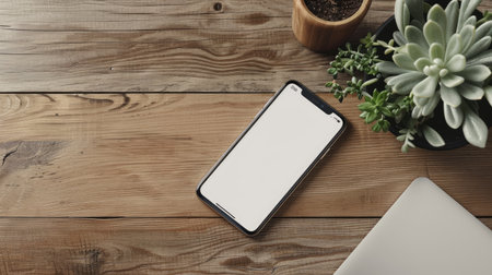 Modern smartphone with a blank screen on a wooden deskの素材