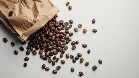 Artfully arranged coffee beans spill from a brown paper bag onto a white background, inviting the viewer to indulge in a sensory coffee experienceの素材