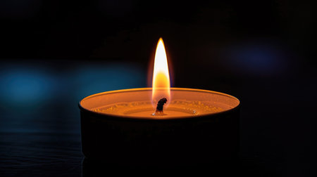 Tranquil candle flame glowing gently in the darkness, bringing a sense of calm and peace to the surroundingsの素材