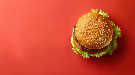 Juicy burger on a vibrant red background, with ample space around for additional text or images.の素材