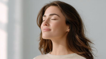 A woman with a relaxed expression enjoys the cool breeze of air conditioning, immersed in a moment of tranquility and beauty in a modern indoor setting.の素材