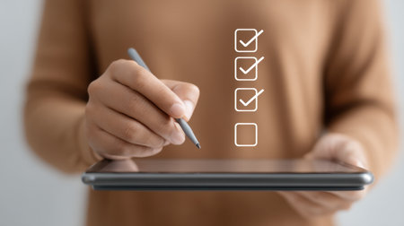 A person uses a stylus on a tablet to efficiently complete a digital checklist, showcasing modern productivity tools and the convenience of technology in daily tasks.の素材