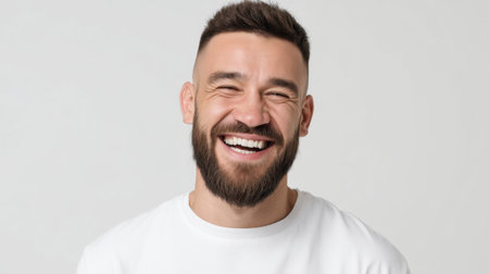 A cheerful man smiles broadly, showcasing his clean white teeth. This bright portrait captures a joyful expression against a minimalist background, radiating positivity.の素材