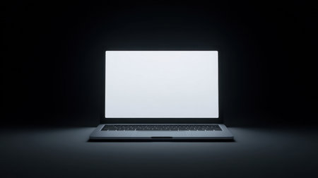 A minimal workspace featuring a softly glowing laptop screen against a dark background, ideal for promoting productivity and tranquility in creative environments.の素材