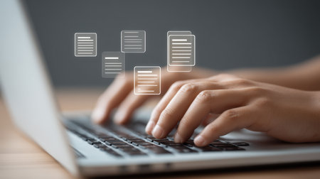 A close-up image of hands typing on a laptop keyboard with holographic documents floating above, symbolizing digital innovation and modern workspace efficiency.の素材