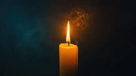 A single illuminated candle flickering against a velvety black background, casting a warm glow.の素材