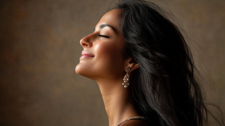 A serene portrait of an elegant woman with flowing hair in profile, showcasing her natural beauty and grace against a soft, dark background.の素材