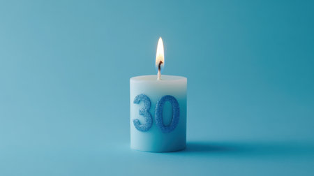 A blue candle featuring the number 30 sits lit against a light blue background. Ideal for birthday celebrations, this candle adds a vibrant and festive touch to special occasions.の素材