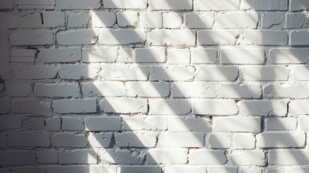 White brick wall background with natural light and shadow play.の素材