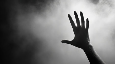 A haunting silhouette of a hand reaching out through swirling smoke evokes feelings of fear and mystery. This dramatic image captures deep emotion and isolation.の素材