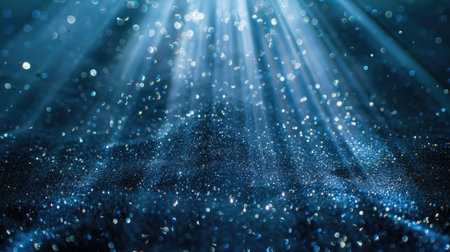 Blue glitter particles falling in a continuous loop, illuminated by delicate light rays for an enchanting effectの素材