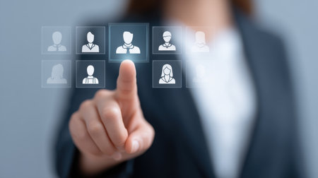 A business specialist uses a digital interface to conduct team selection, showcasing strategic decision-making in a modern professional environment focused on talent.の素材