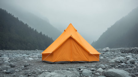 A vibrant orange tent stands alone in a serene, foggy landscape, surrounded by rocky terrain and mountainous backdrops, inviting outdoor enthusiasts for tranquility and adventure.の素材