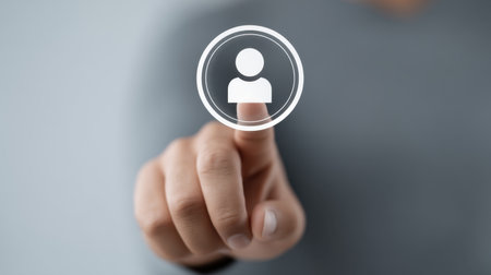 A close-up image of a hand pressing a digital icon representing a user profile, illustrating modern interaction with technology and digital interfaces in everyday life.の素材