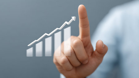 This image showcases a professional hand pointing at an upward trending graph, symbolizing growth and success in data presentation for business analysis.の素材